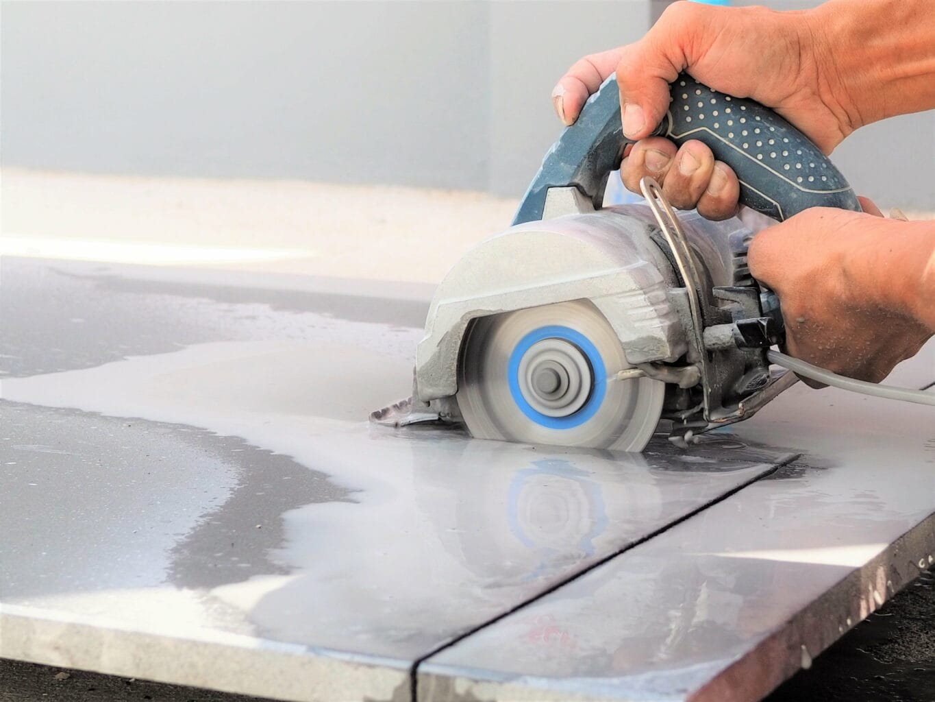 a person cutting tile using a tile cutter. 