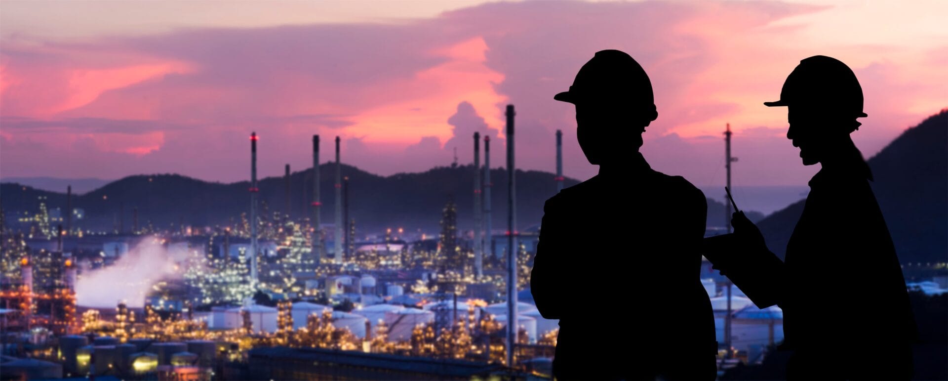 two mine workers overlooking a mine site from a distance. 